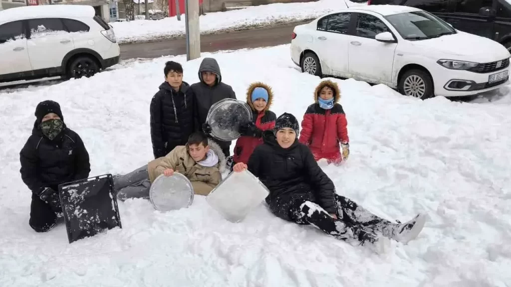 Sivas’ta yoğun kar sonrası öğrenciler tepsi kayarken eğlendi